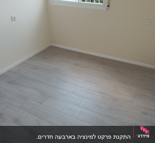 רצפת פרקט עץ בהירה בחדר ריק עם חלון